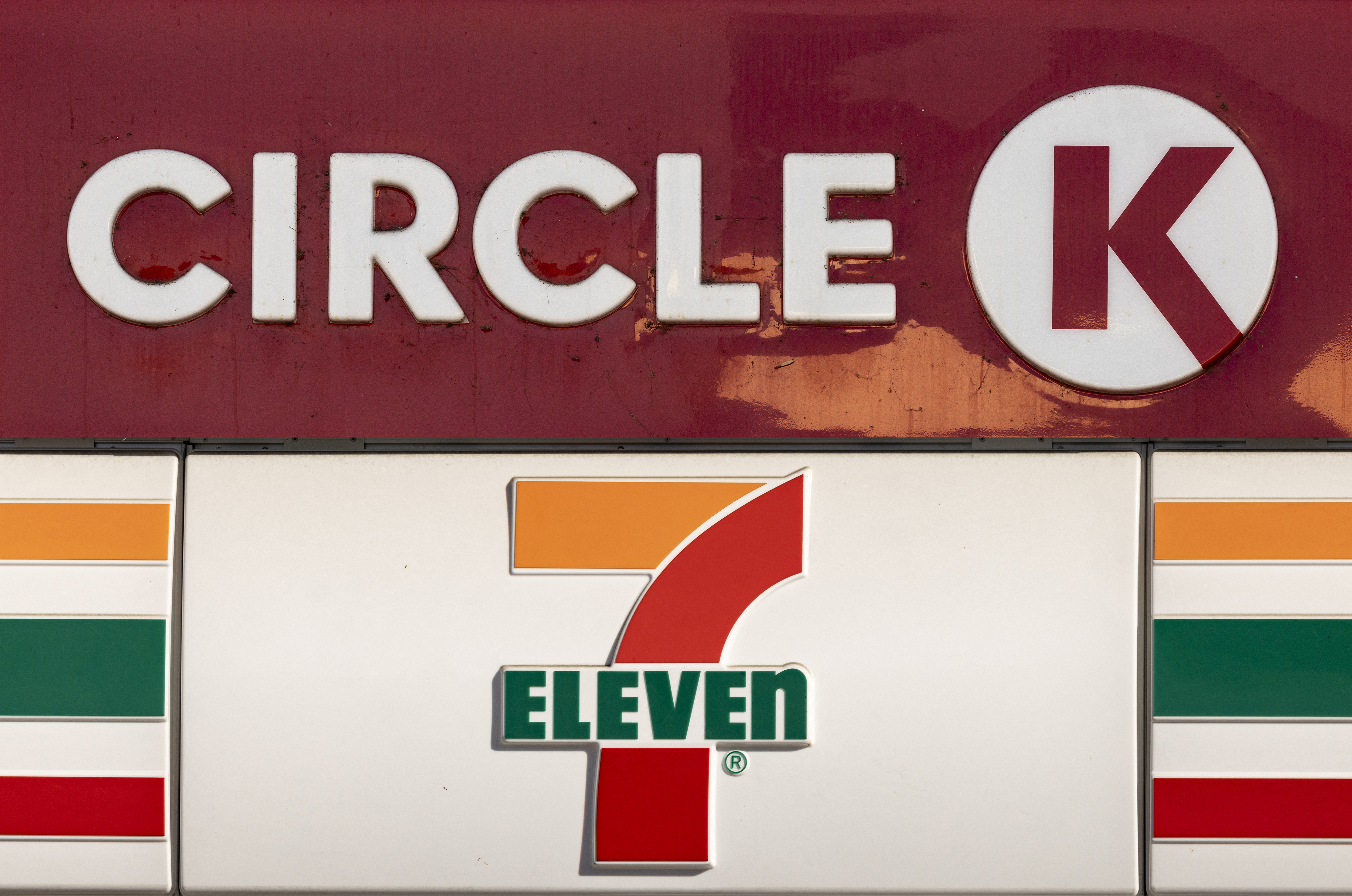 This combination of pictures created on November 20, 2024 shows convenience stores 7-Eleven and Circle K logos in Los Angeles, California, The Japanese owner of 7-Eleven is considering going private by buying back its own shares in a bid to avoid a takeover by Canadian rival Couche-Tard, reports said on November 20. Seven & i Holdings is eyeing the move as a countermeasure to Circle K owner Alimentation Couche-Tard's seven trillion yen ($45 billion) takeover proposal, the Nikkei business daily said. (Photo by Etienne LAURENT / AFP) (Photo by ETIENNE LAURENT/AFP via Getty Images)