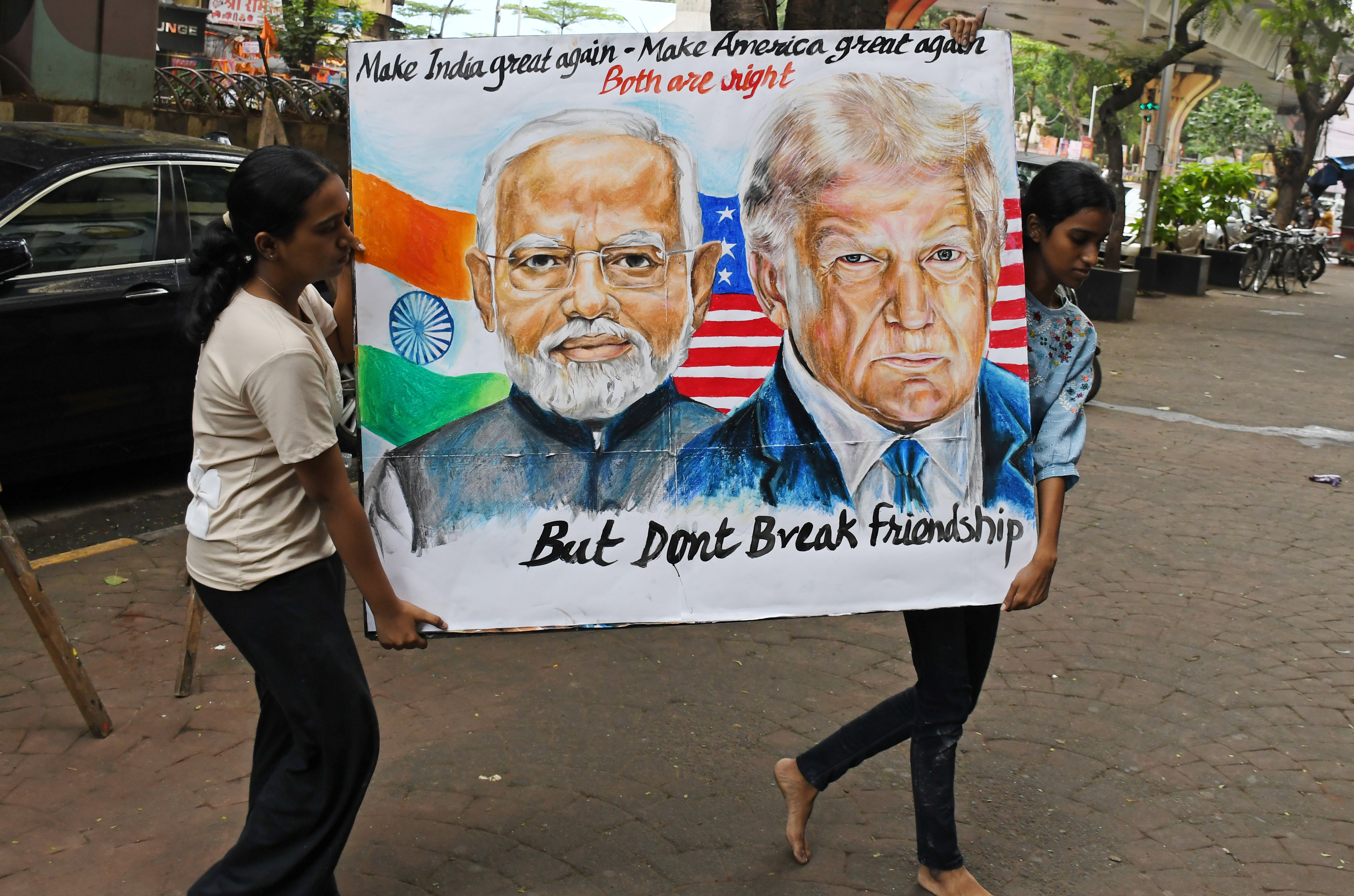 MUMBAI, MAHARASHTRA, INDIA - 2025/08/01: Students from Gurukul School of Art carry a poster of Prime Minister of India Narendra Modi and U.S. President Donald Trump outside their school. U.S. President Donald Trump imposed a 25% tariff on India along with penalties for buying oil and military equipments from Russia. (Photo by Ashish Vaishnav/SOPA Images/LightRocket via Getty Images)