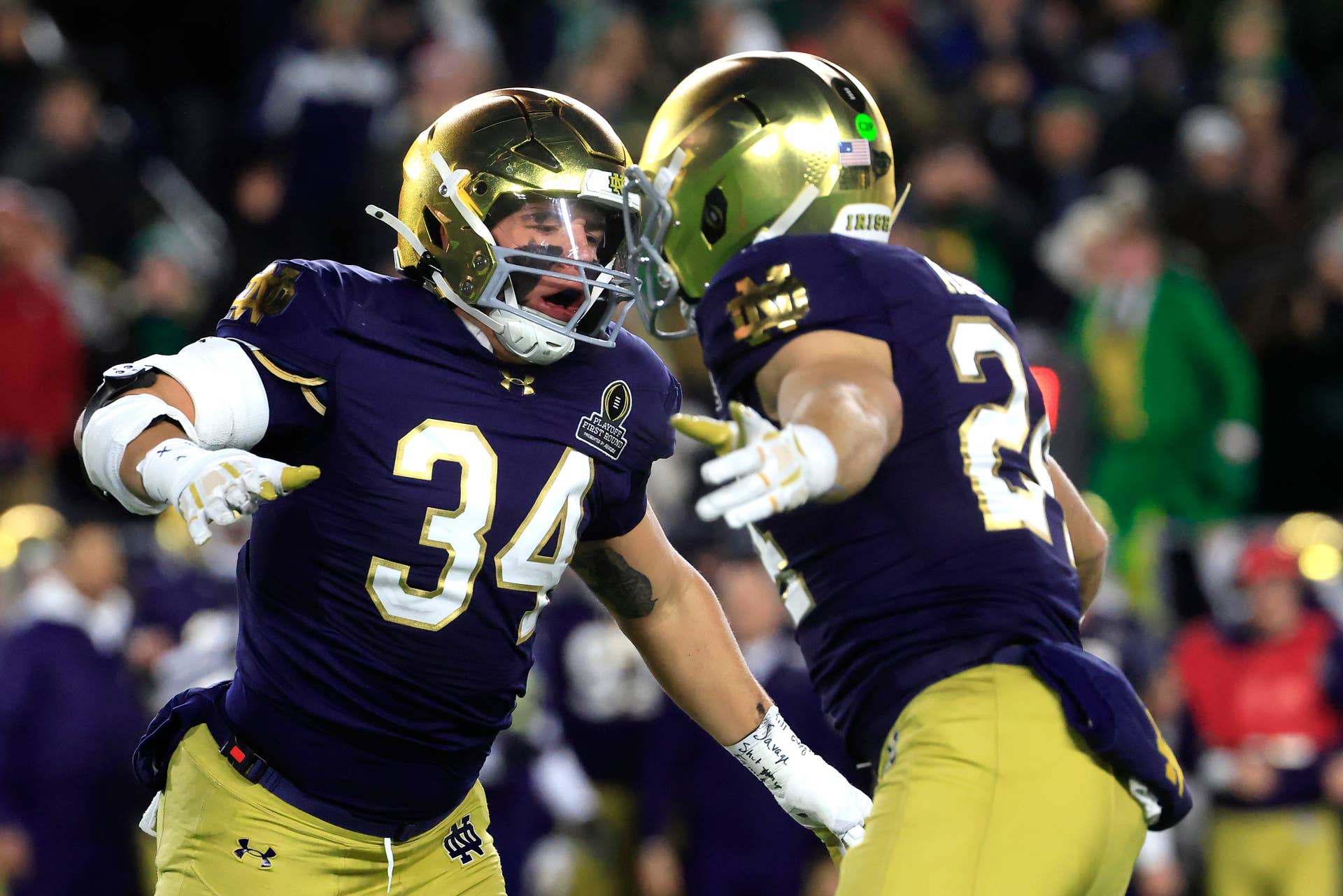 SOUTH BEND, INDIANA - DECEMBER 20: Drayk Bowen #34 and Jack Kiser #24 of the Notre Dame Fighting Irish celebrate after a defensive play during the first quarter against the Indiana Hoosiers in the Playoff First Round game at Notre Dame Stadium on December 20, 2024 in South Bend, Indiana. (Photo by Justin Casterline/Getty Images)